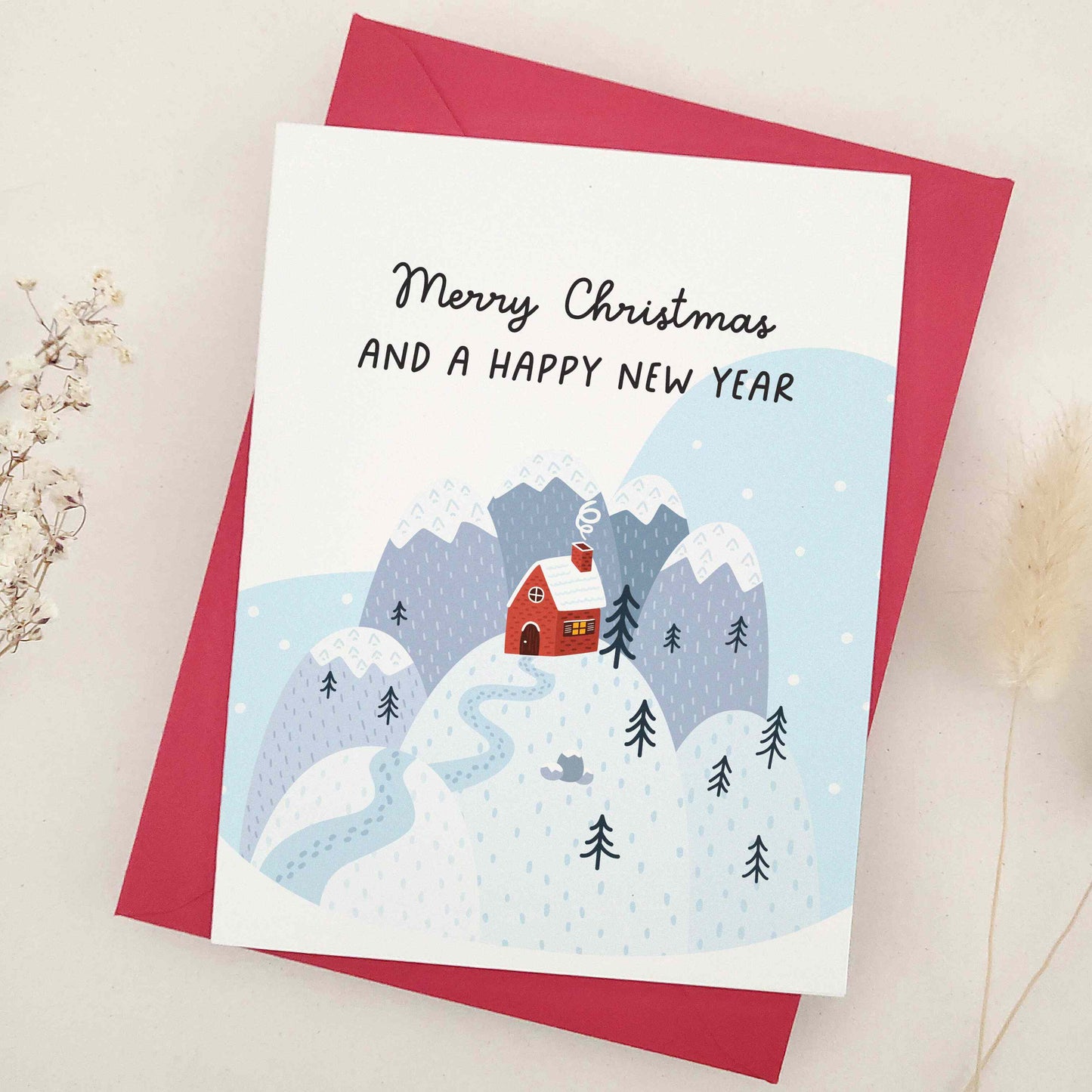 Serene 'Merry Christmas and a Happy New Year' card capturing the tranquil aspect of the festive season, with an illustration of a solitary house in a snow-covered landscape. The picturesque scenery evokes calmness and the simple joys of a quiet winter's day, reflecting a moment of solitude and reflection amidst the bustling holiday festivities, perfect for sharing unique and thoughtful festive greetings.