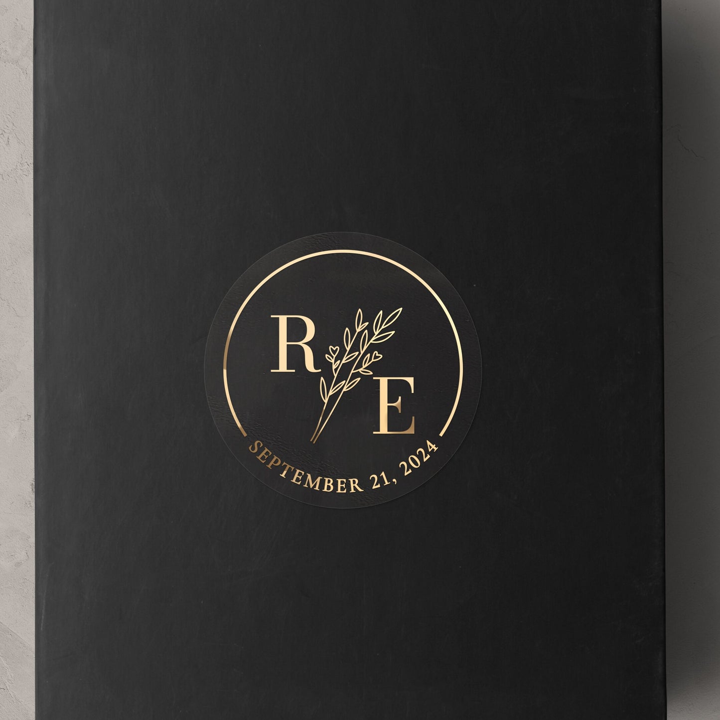 Transparent wedding sticker with golden initials and date, featuring an elegant botanical design