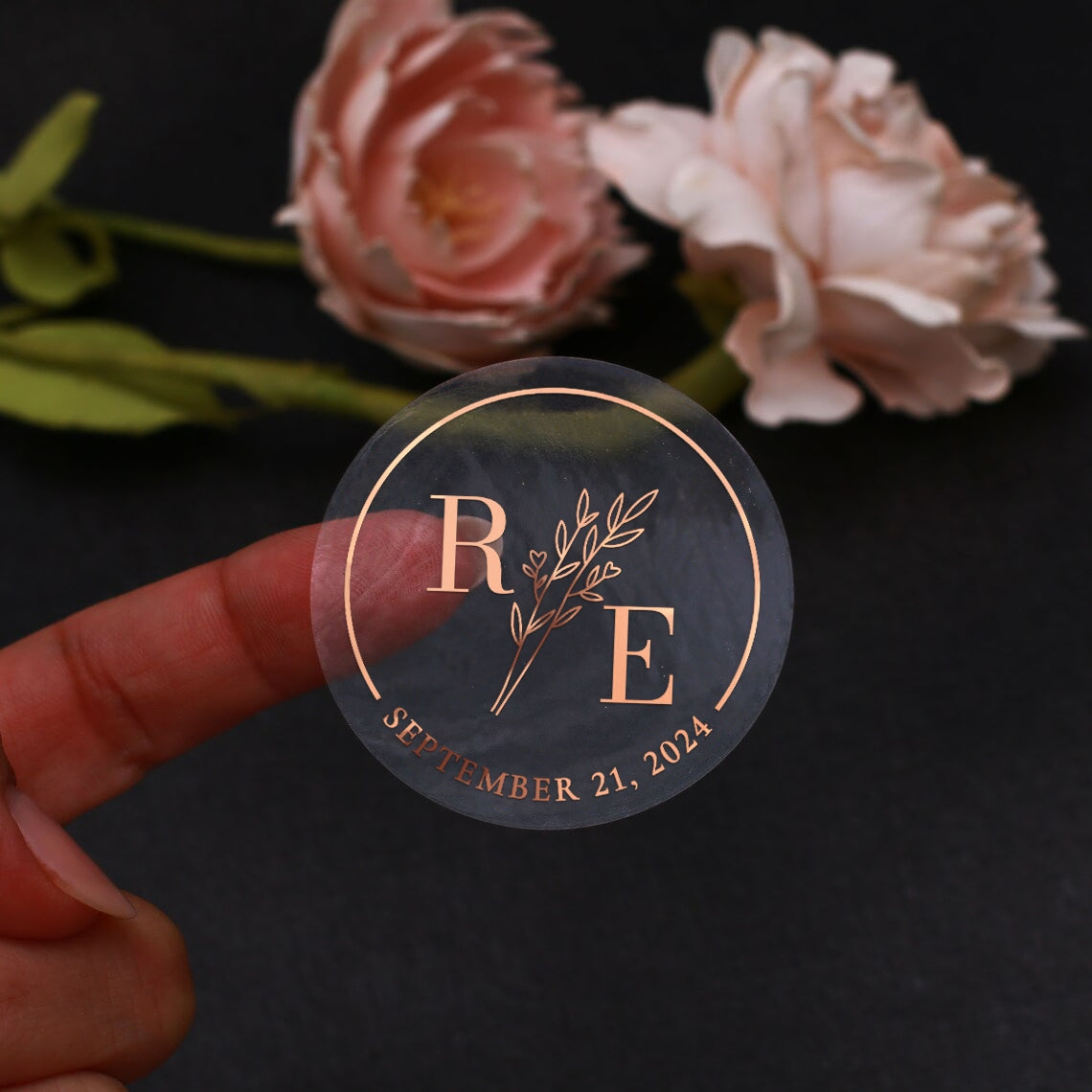 Transparent wedding sticker with golden initials and date, featuring an elegant botanical design
