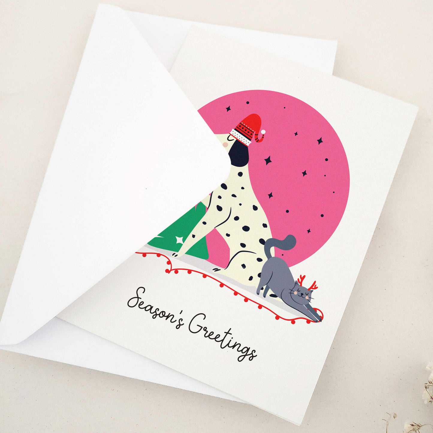 Unleash the holiday spirit with our adorable 'Season's Greetings' card, featuring a festive spotted dog and a cheerful companion decorating a Christmas tree under a starry night sky, perfect for dog lovers and fans of playful designs.