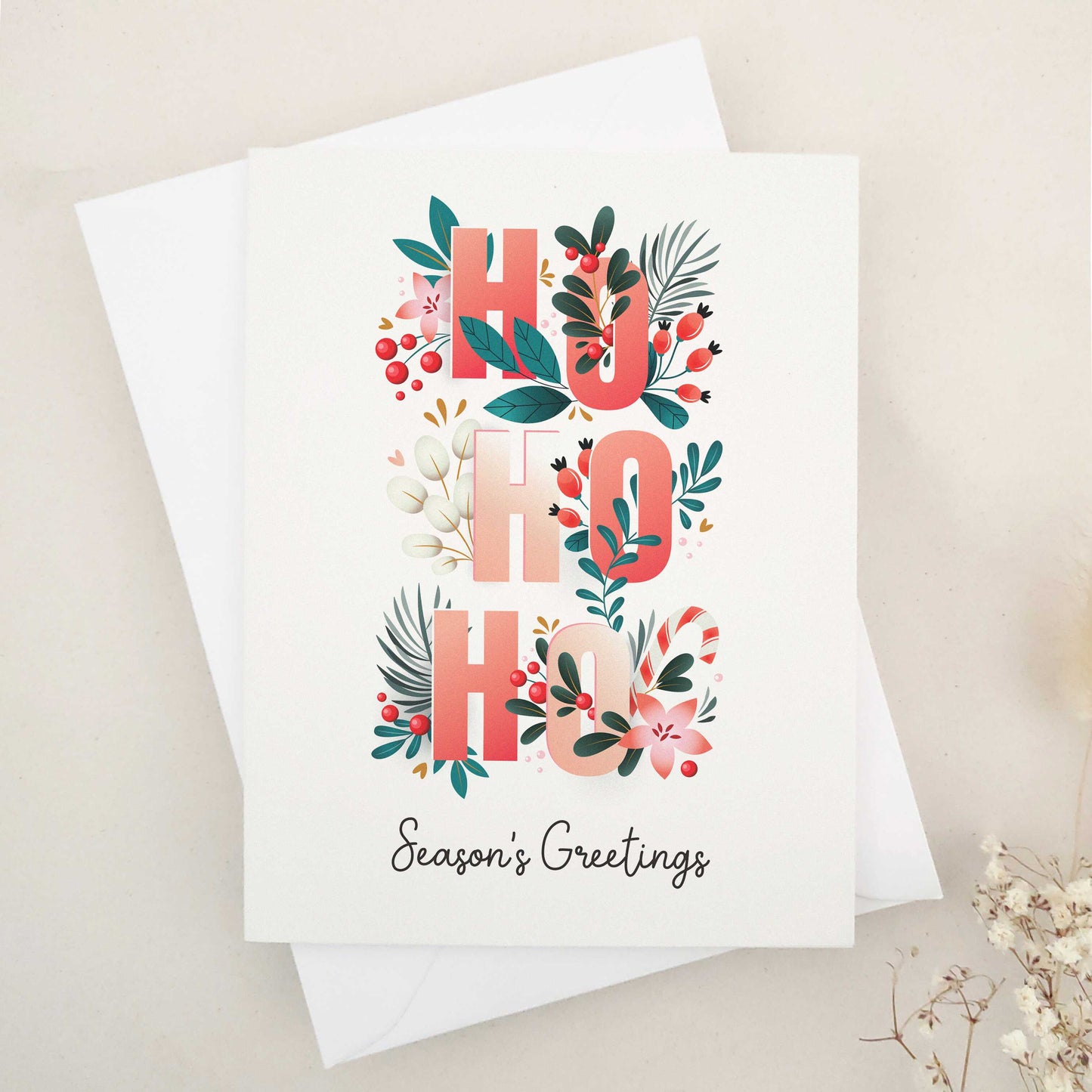 Spread holiday cheer with our beautifully crafted 'Ho Ho Ho' Season's Greetings card, featuring festive flowers, Christmas berries, and a playful 'Ho Ho Ho' typographic arrangement, a heartfelt way to celebrate the season.