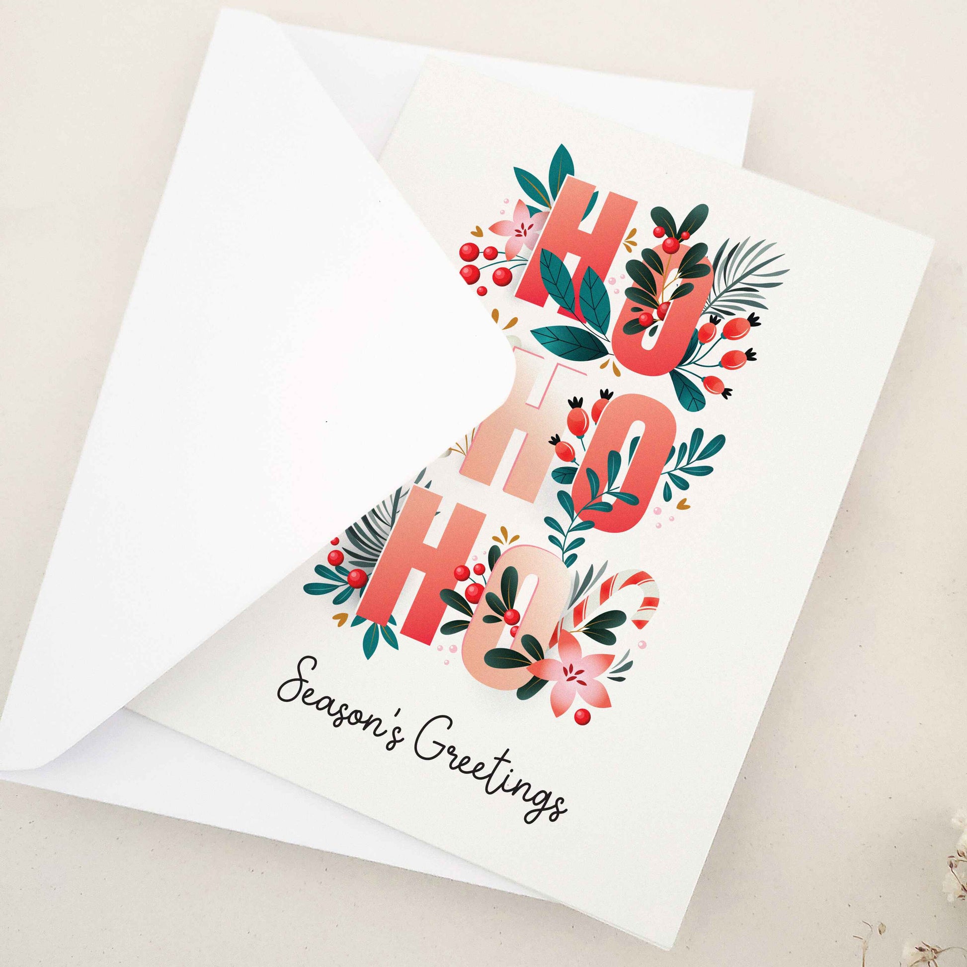 Spread holiday cheer with our beautifully crafted 'Ho Ho Ho' Season's Greetings card, featuring festive flowers, Christmas berries, and a playful 'Ho Ho Ho' typographic arrangement, a heartfelt way to celebrate the season.