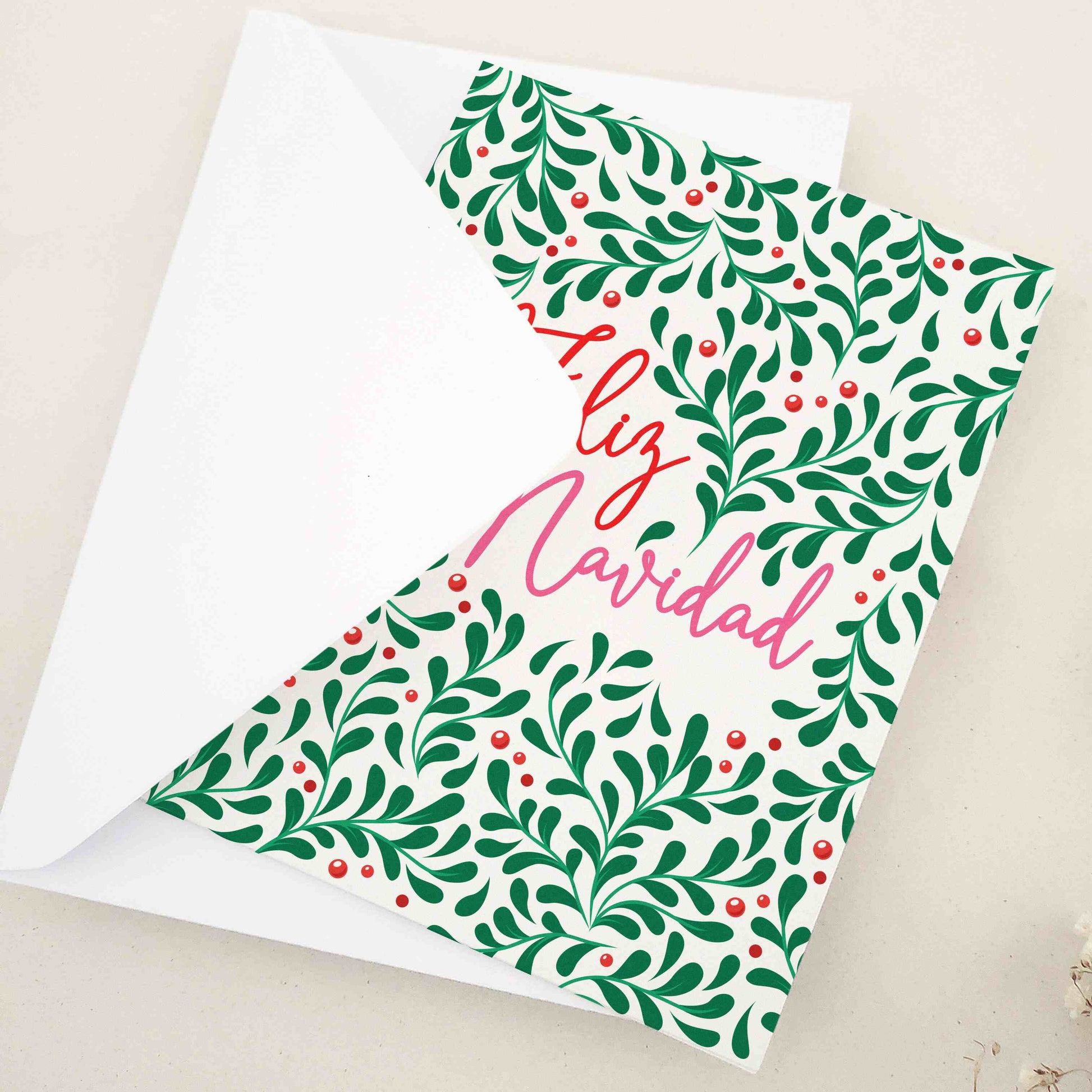 Vibrant 'Feliz Navidad' card, richly decorated with a lush pattern of greenery and berries, embodying the traditional charm and warmth of Hispanic culture. The design, symbolizing life and joy, is a heartwarming choice for conveying holiday wishes, offering a visually stunning and meaningful way to share season's greetings.