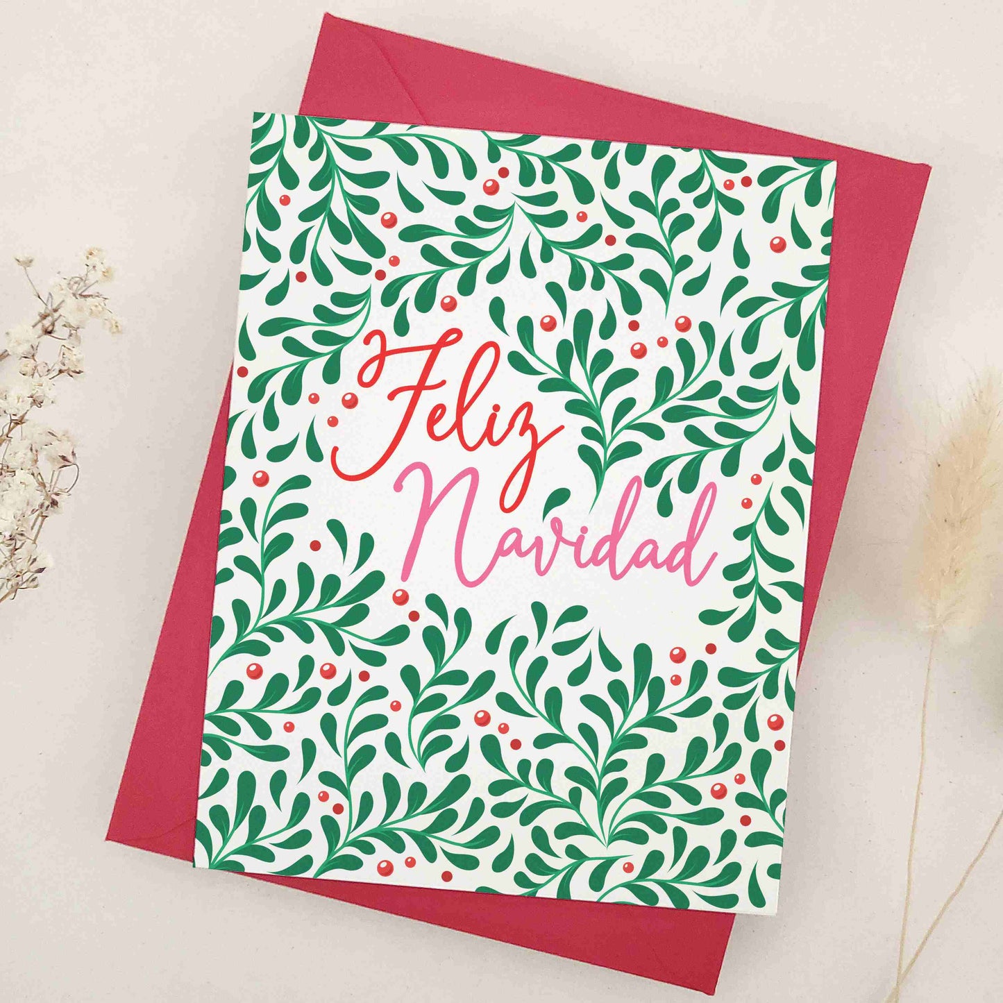 Vibrant 'Feliz Navidad' card, richly decorated with a lush pattern of greenery and berries, embodying the traditional charm and warmth of Hispanic culture. The design, symbolizing life and joy, is a heartwarming choice for conveying holiday wishes, offering a visually stunning and meaningful way to share season's greetings.
