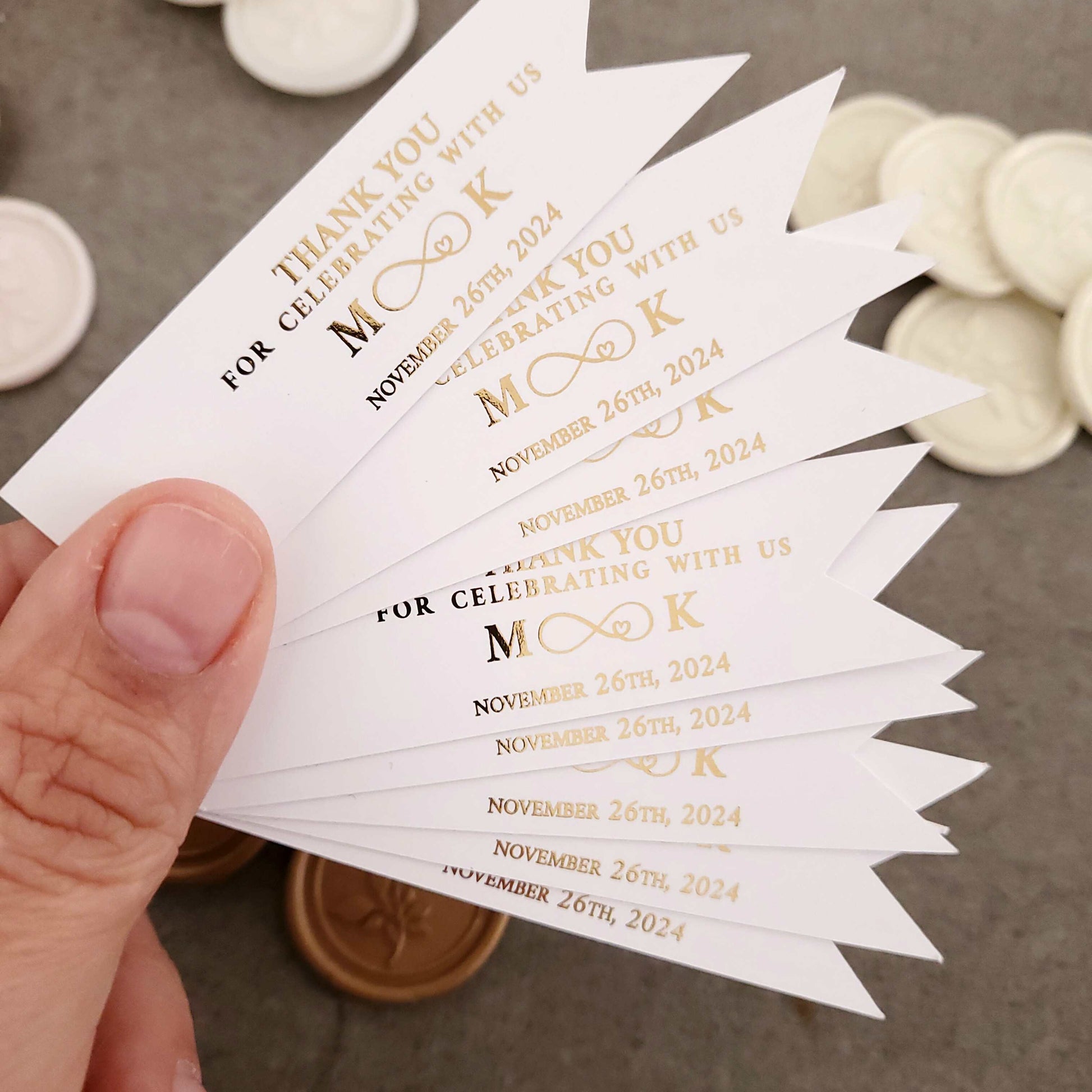 Personalized thank you for celebrating with us wedding favor tags with foiled text, including the couple's initials, an infinity sign and the wedding date.
