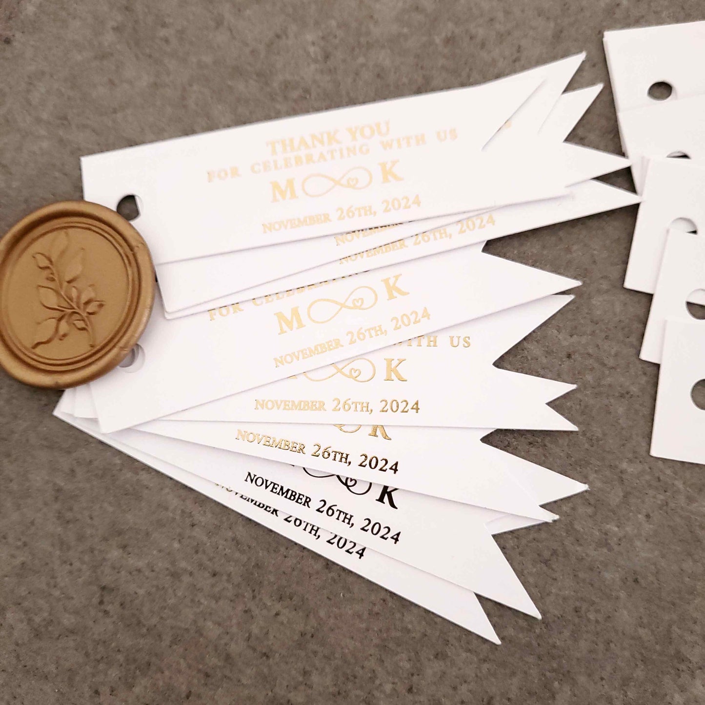 Personalized thank you for celebrating with us wedding favor tags with foiled text, including the couple's initials, an infinity sign and the wedding date.
