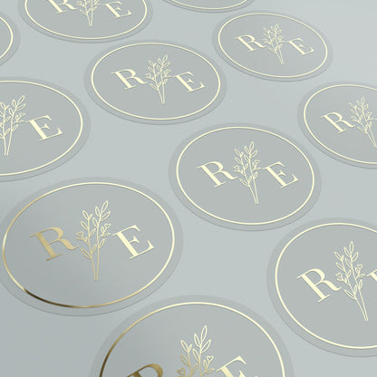 Clear custom wedding sticker with golden initials and botanical illustration.