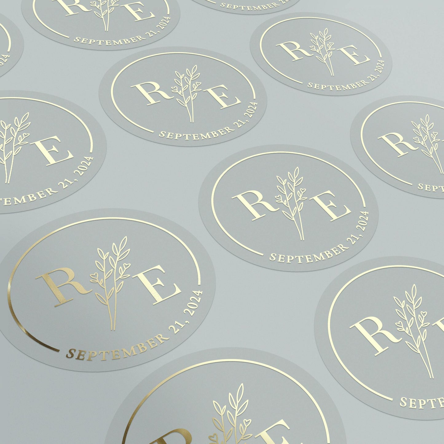 Transparent wedding sticker with golden initials and date, featuring an elegant botanical design