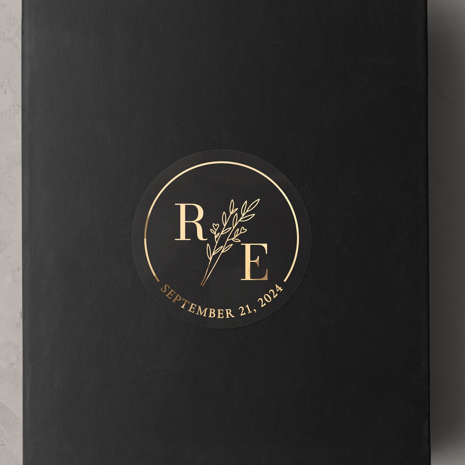 Transparent wedding sticker with golden initials and date, featuring an elegant botanical design