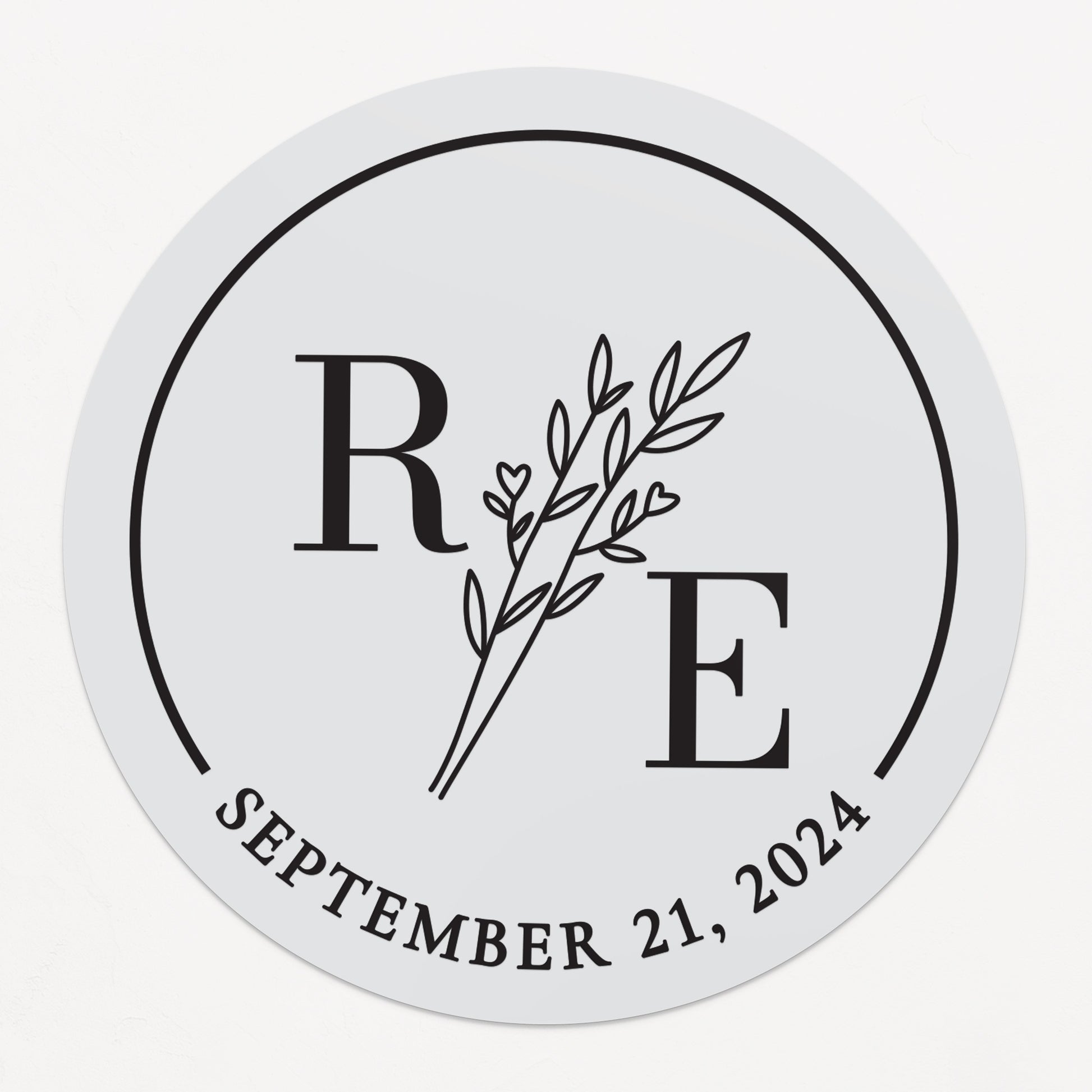 Transparent wedding sticker with golden initials and date, featuring an elegant botanical design