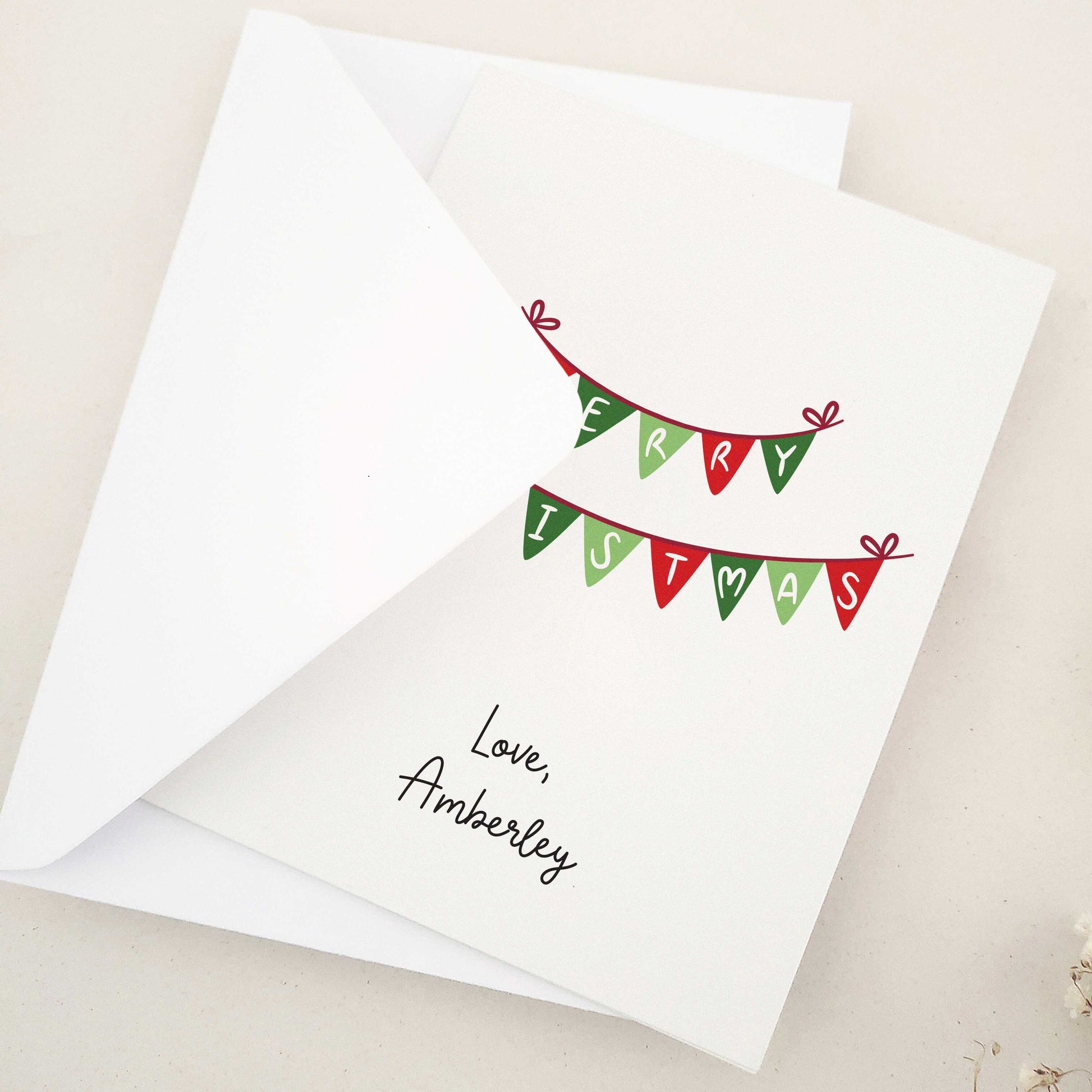 Embrace the festive season with our classic 'Merry Christmas' card: a beautifully simple yet elegant choice featuring traditional Christmas bunting in warm holiday colors, delicately spelling out heartfelt holiday greetings.