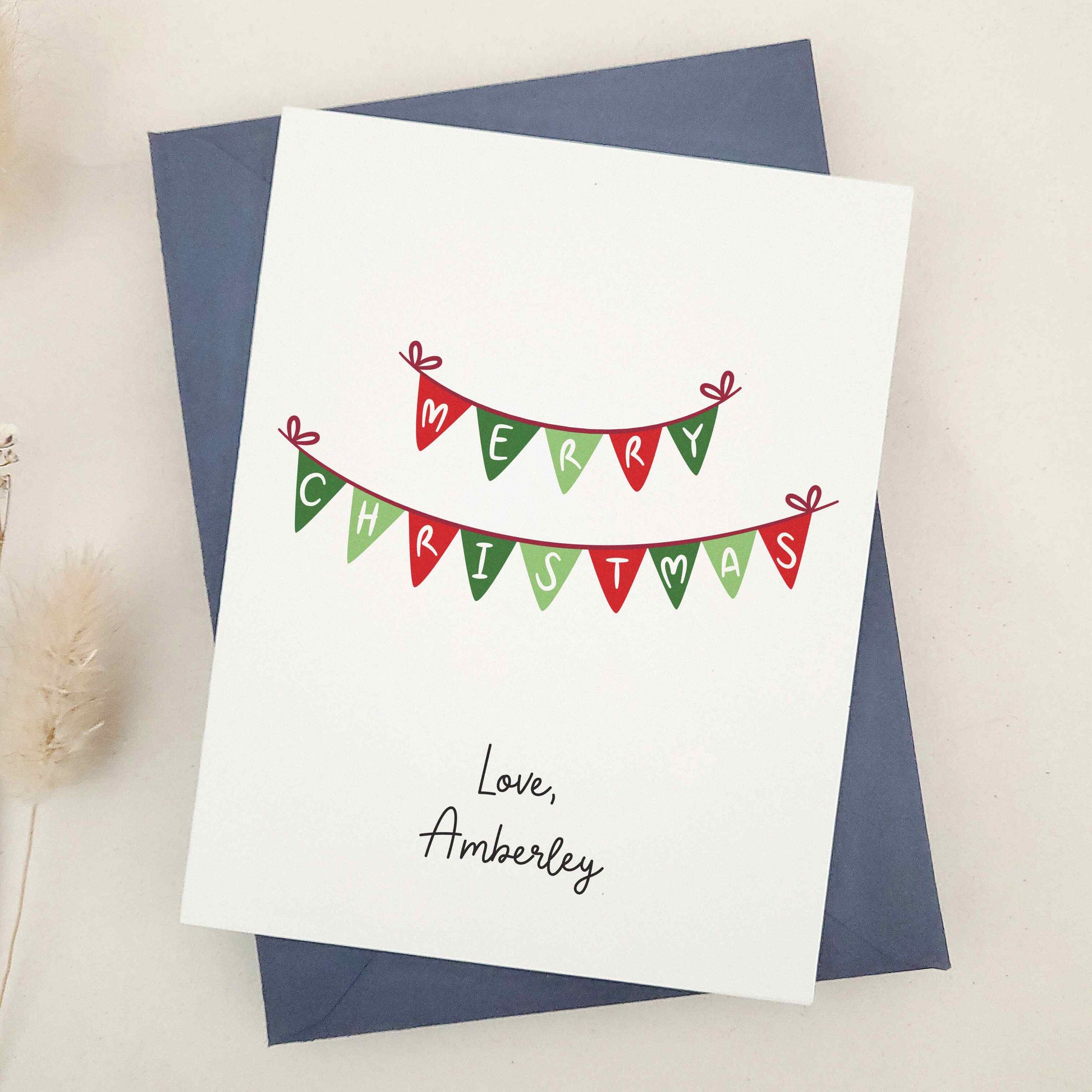 Embrace the festive season with our classic 'Merry Christmas' card: a beautifully simple yet elegant choice featuring traditional Christmas bunting in warm holiday colors, delicately spelling out heartfelt holiday greetings.