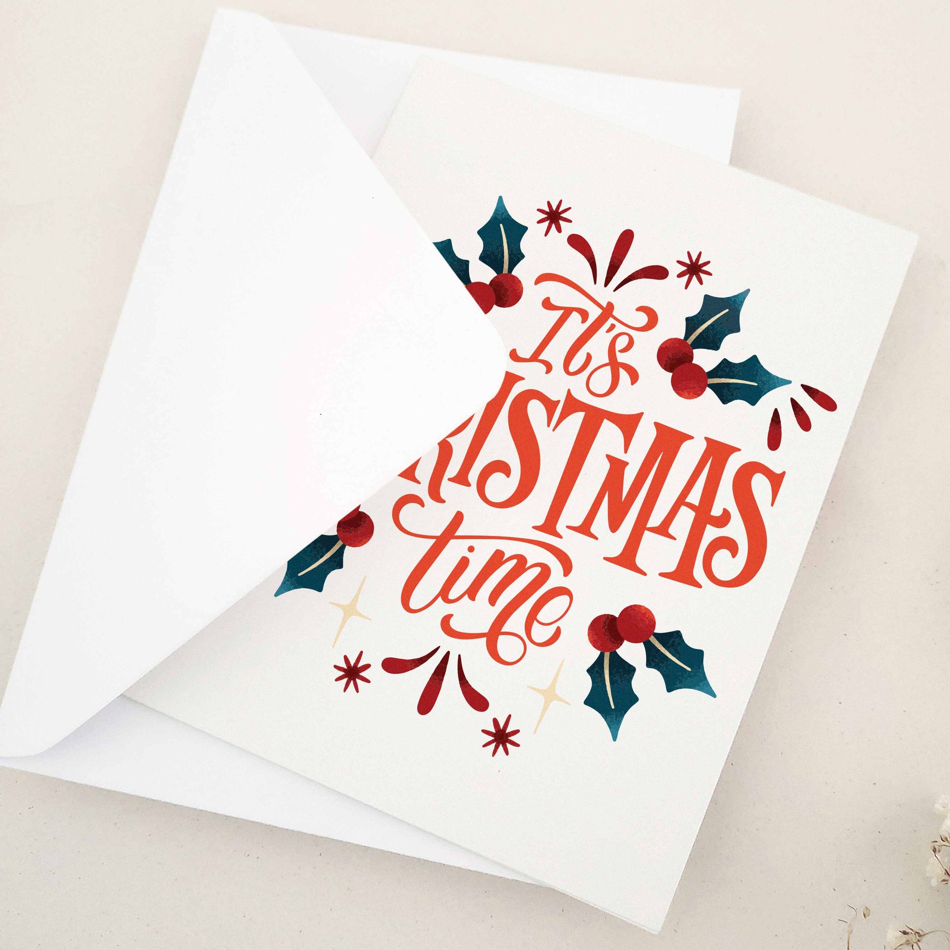 Elegant 'It's Christmas Time' card, lavishly expressing holiday excitement and joy, adorned with traditional holly leaves and berries. Features a beautifully styled typographic design as the centerpiece, joyously announcing the season and capturing the essence of holiday merriment. This card combines classic holiday imagery with modern typographic flair, making it a sophisticated and festive choice for season's greetings.