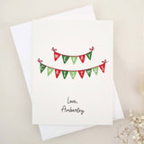 Merry Christmas greeting card with red and green bunting banner design, paired with white envelope – XOXOKristen