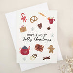 Folded holiday card featuring playful festive icons like gingerbread, candy, snowflakes, ribbon, and hot cocoa mug, displayed with envelope — XOXOKristen.