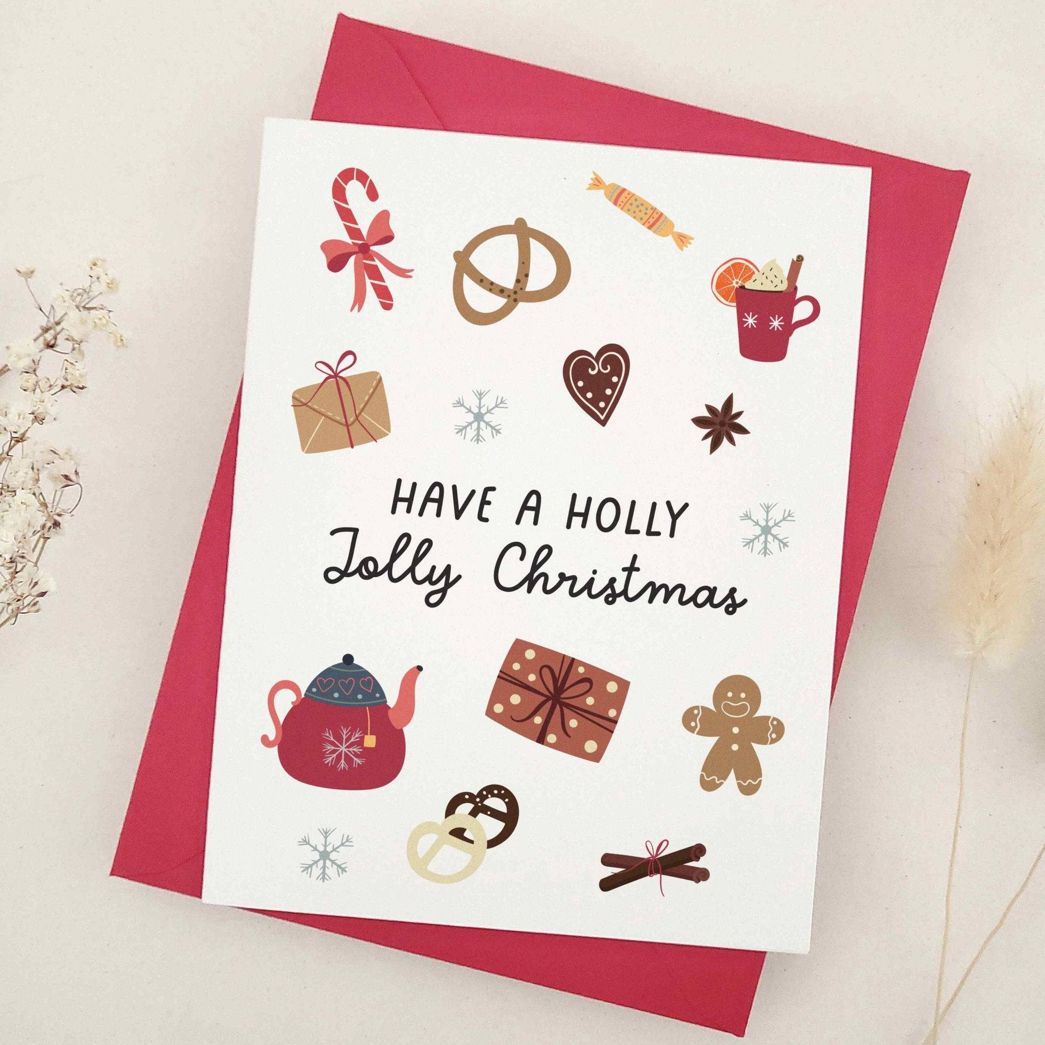 Christmas card with “Have a Holly Jolly Christmas” in black script, decorated with gingerbread cookie, candy cane, teapot, wrapped gift, pretzel, ribbon, and snowflakes, paired with red envelope — XOXOKristen.