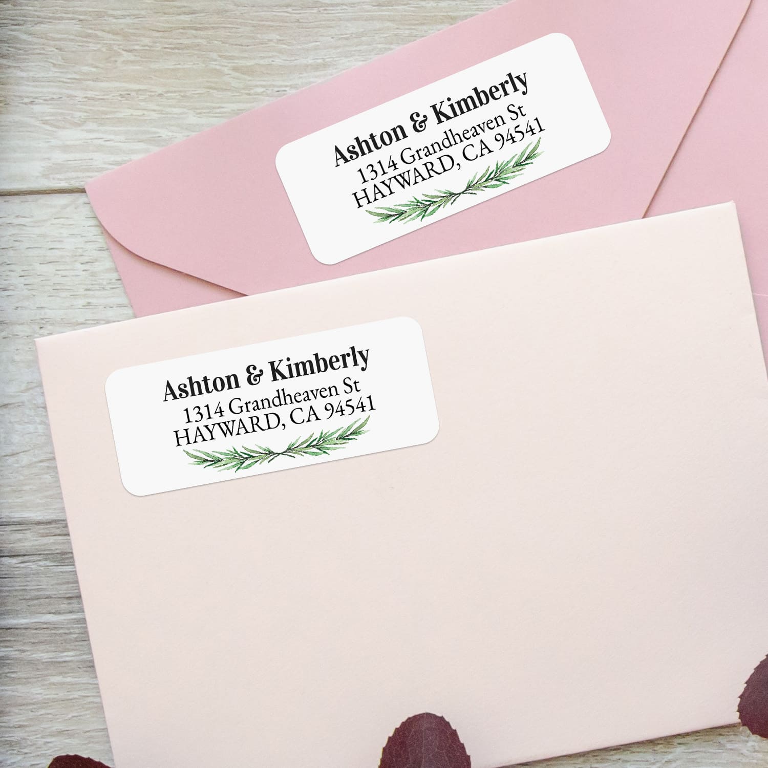 Close-up of return address label featuring realistic pine branch greenery and bold black text on a crisp white background - XOXOKristen