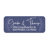 Close-up of custom navy return address label with laurel leaves framing elegant white script typography, printed on rectangular sticker - XOXOKristen