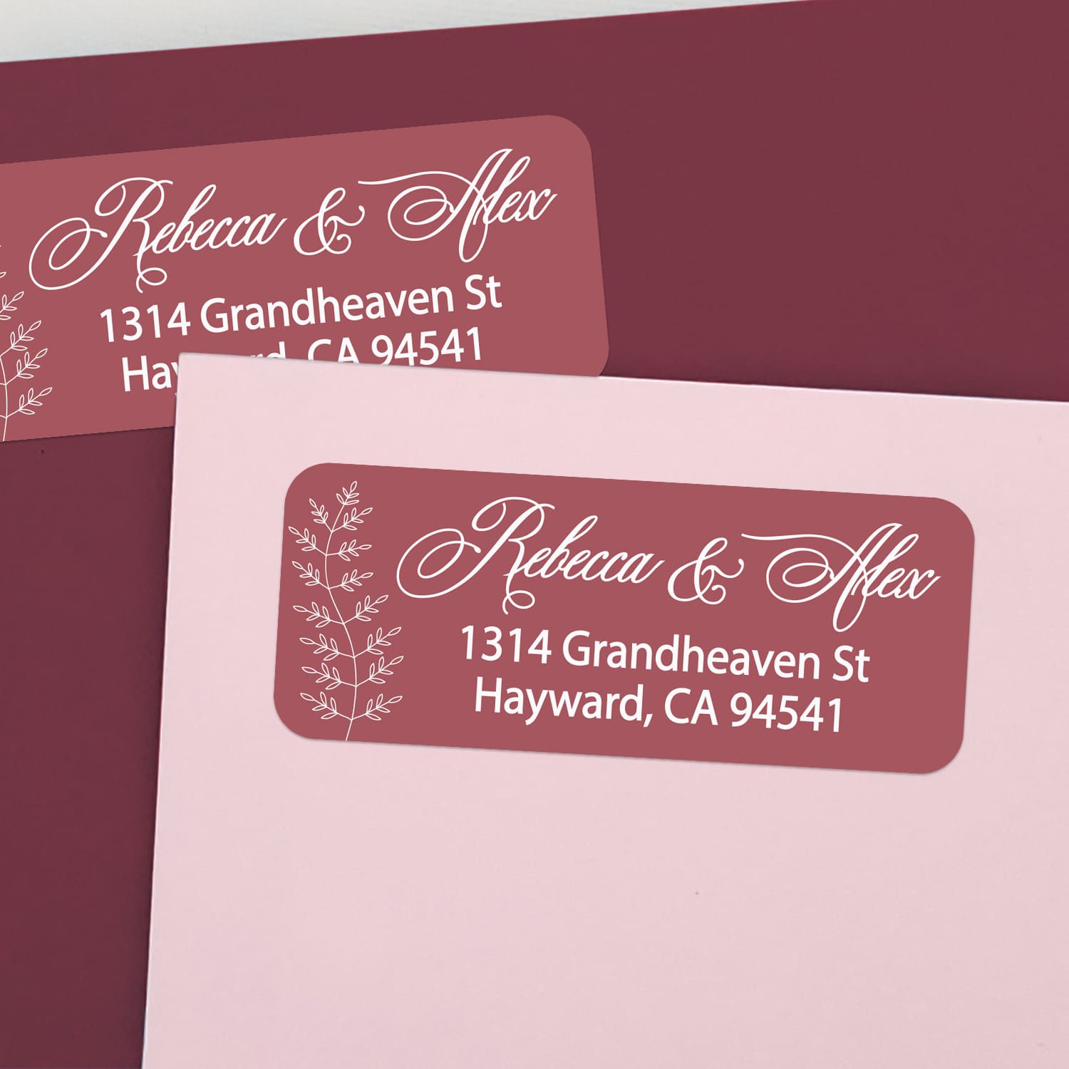 Custom return address labels on pink and burgundy envelopes, featuring burgundy background with floral vine accents and elegant white text - XOXOKristen