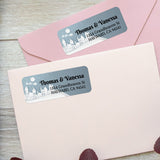 Custom holiday return address labels on pink and burgundy envelopes, featuring snowy houses, moon, and Santa sleigh design - XOXOKristen
