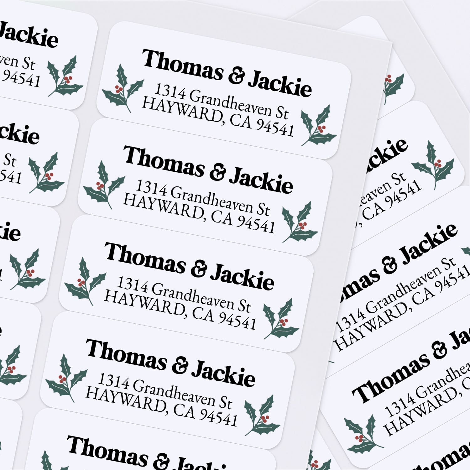 Custom Christmas return address labels on pink and burgundy envelopes, decorated with festive holly branch motifs and printed text - XOXOKristen