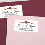 Personalized return address label sticker on burgundy envelope, decorated with floral accents and elegant script — XOXOKristen.