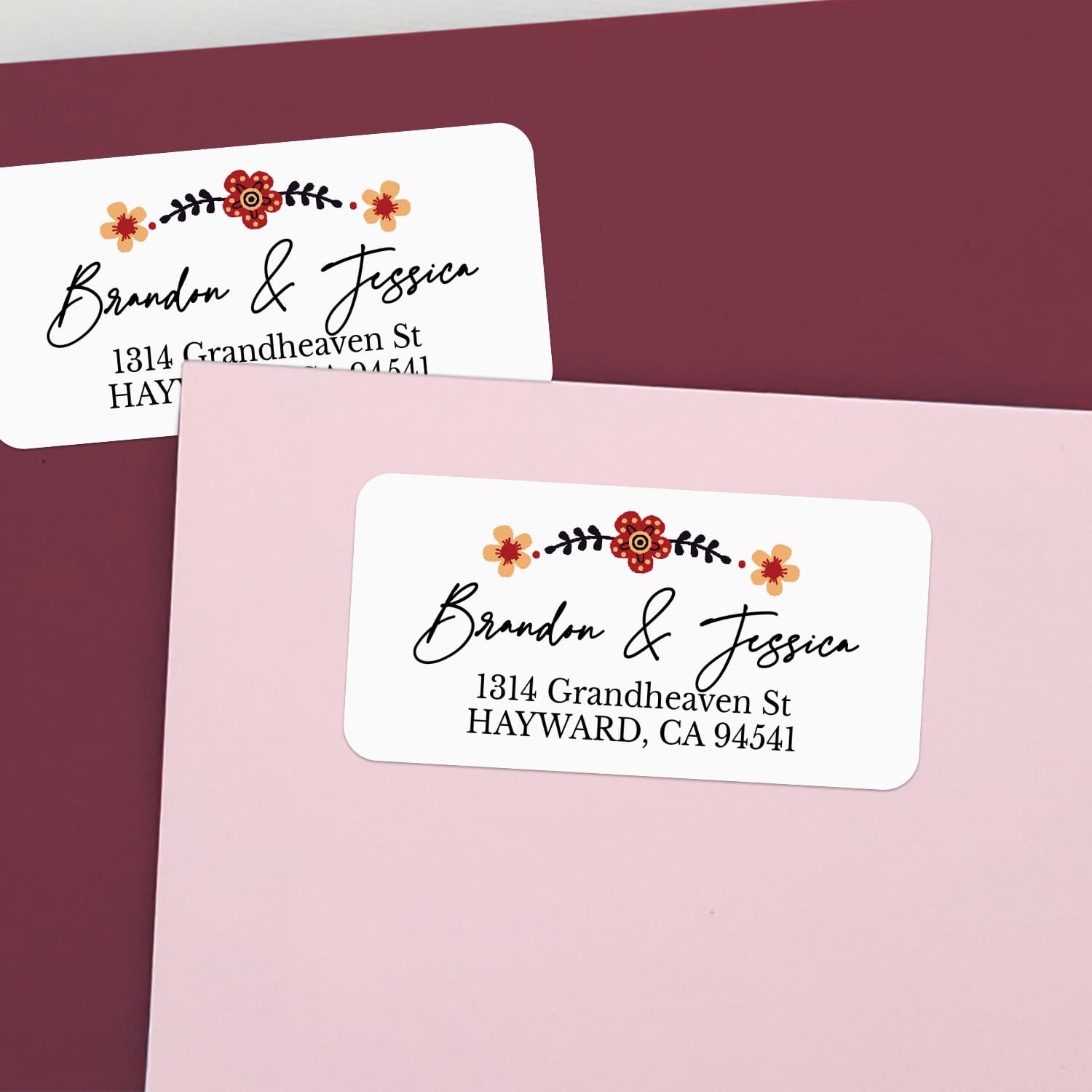 Personalized return address label sticker on burgundy envelope, decorated with floral accents and elegant script — XOXOKristen.
