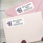 Custom address label on pink envelope featuring decorative red and blue initial H with floral design and elegant black printed names and address - XOXOKristen