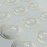 XOXOKristen clear round wedding stickers with foiled monogram, displayed in sheets, customizable labels for save the date, favors, and bridal showers