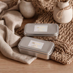 Metallic gold foil rectangular branding labels on silver tins, featuring elegant script design with contrasting serif details – XOXOKristen.