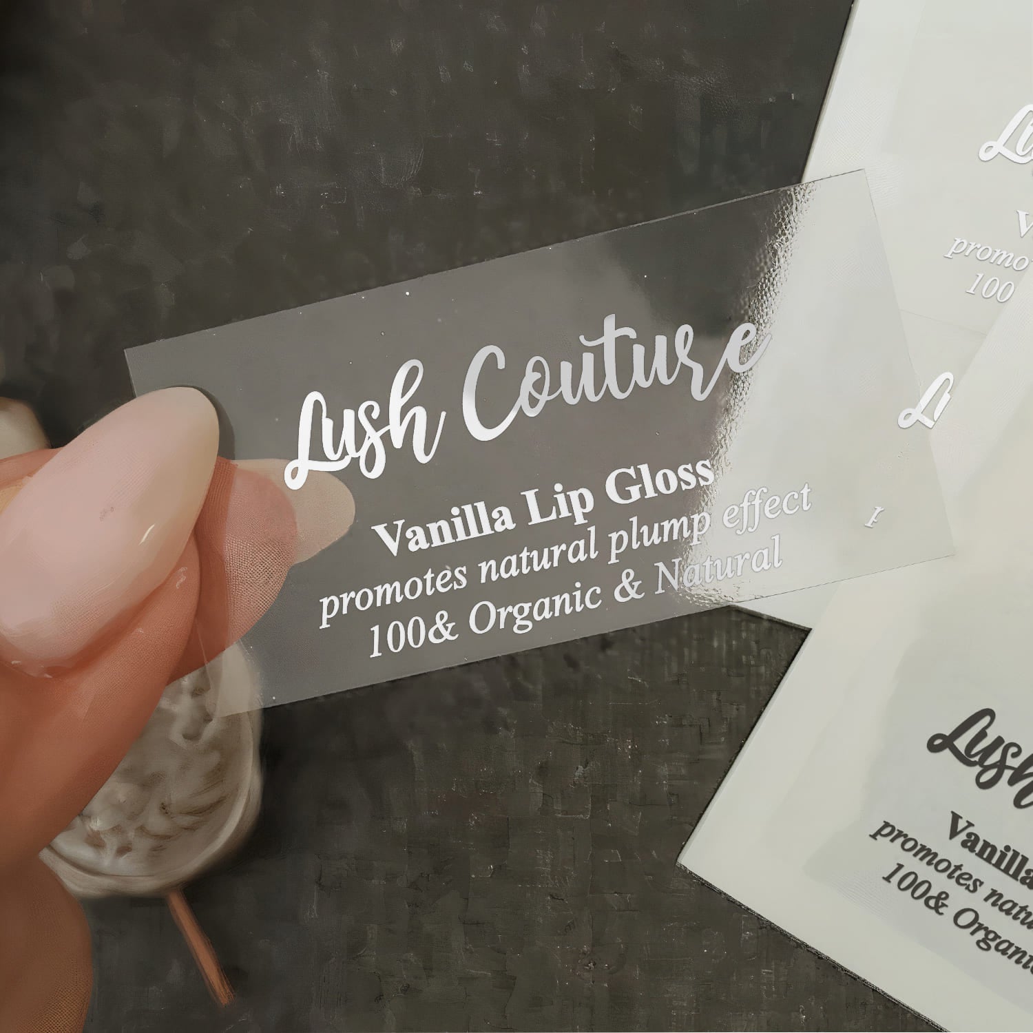 Clear transparent vinyl branding label with glossy finish, modern script and serif typography design shown up close – XOXOKristen.