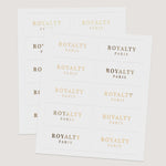 Sheets of rectangular branding labels with uppercase serif typography in metallic foils and black print, minimalist design – XOXOKristen.