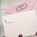 XOXOKristen gold foil personalized return address label with laurel leaf accents, printed on clear PVC vinyl, shown applied to navy envelope - XOXOKristen