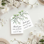 XOXOKristen Eucalyptus Branch Thank You Tags displayed on a white floral background with botanical leaves cascading from the top, showcasing the minimal printed message “Thank you.”