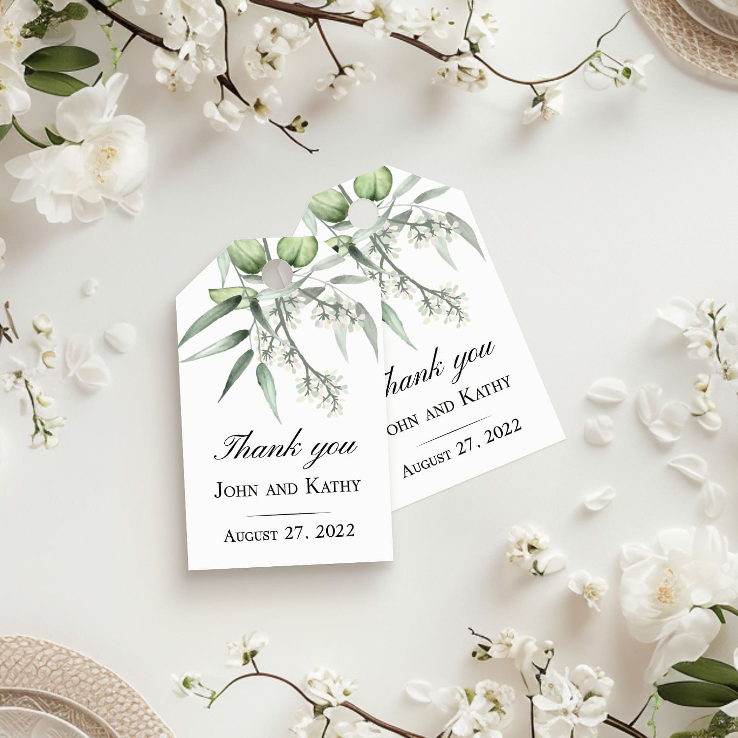 XOXOKristen Eucalyptus Branch Thank You Tags displayed on a white floral background with botanical leaves cascading from the top, showcasing the minimal printed message “Thank you.”