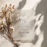 XOXOKristen custom vellum Save the Date card printed in metallic silver foil with elegant calligraphy and classic layout, surrounded by white spring flowers on soft neutral background – XOXOKristen.