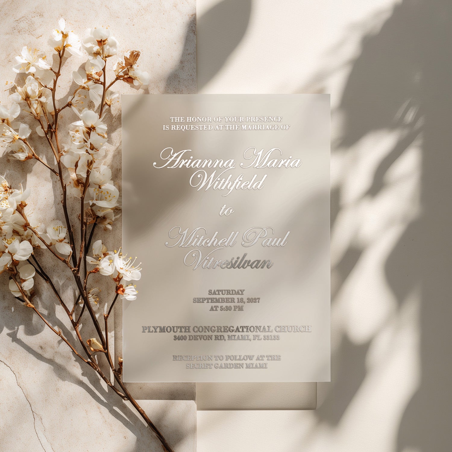 translucent vellum wedding invitation with silver ink printed text, styled with blooming white flowers and natural shadows over a soft beige background, minimalist and romantic wedding stationery design for elegant celebrations – XOXOKristen
