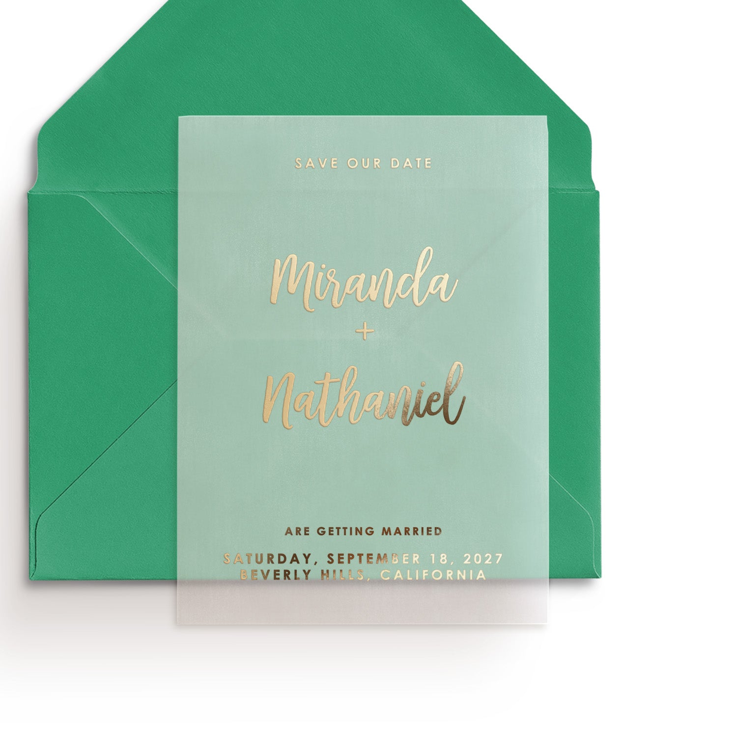 Modern translucent vellum Save the Date card in gold foil with minimalist typography and elegant script font, placed in emerald envelope – XOXOKristen