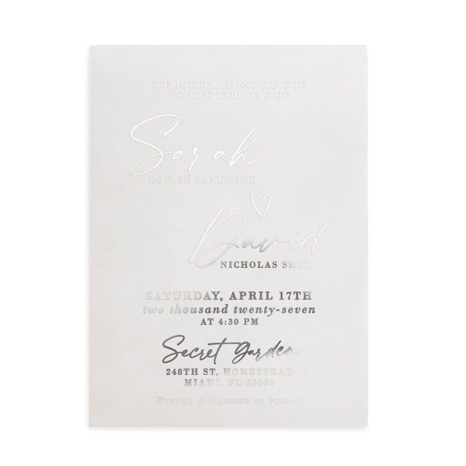 A translucent vellum wedding invitation with metallic silver foil lettering displayed on a natural stone surface beside delicate white blossoming branches. The light and shadows play beautifully across the frosted vellum texture, enhancing the reflective shimmer of the silver foil. The modern fonts and romantic layout create an elegant atmosphere, ideal for spring or garden weddings. – XOXOKristen