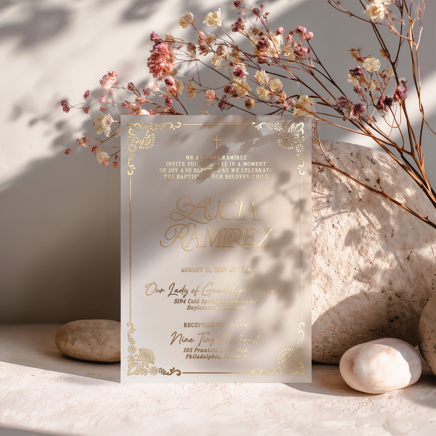 Luxurious vellum baptism invitation in gold foil, surrounded by dried flowers and natural shadows, capturing the sacred elegance of christening celebrations – XOXOKristen