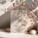 Luxurious vellum baptism invitation in gold foil, surrounded by dried flowers and natural shadows, capturing the sacred elegance of christening celebrations – XOXOKristen