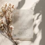 Translucent vellum quinceañera invitation with white text and ornate border, styled with blooming white flowers on a soft stone background with natural light, showcasing romantic minimalist design for elegant celebrations – XOXOKristen