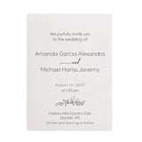 Elegant frosted translucent vellum wedding invitation printed with refined black serif and cursive script with the couples’ names, surrounded by white blossoms and soft beige tones under gentle sunlight. XOXOKristen