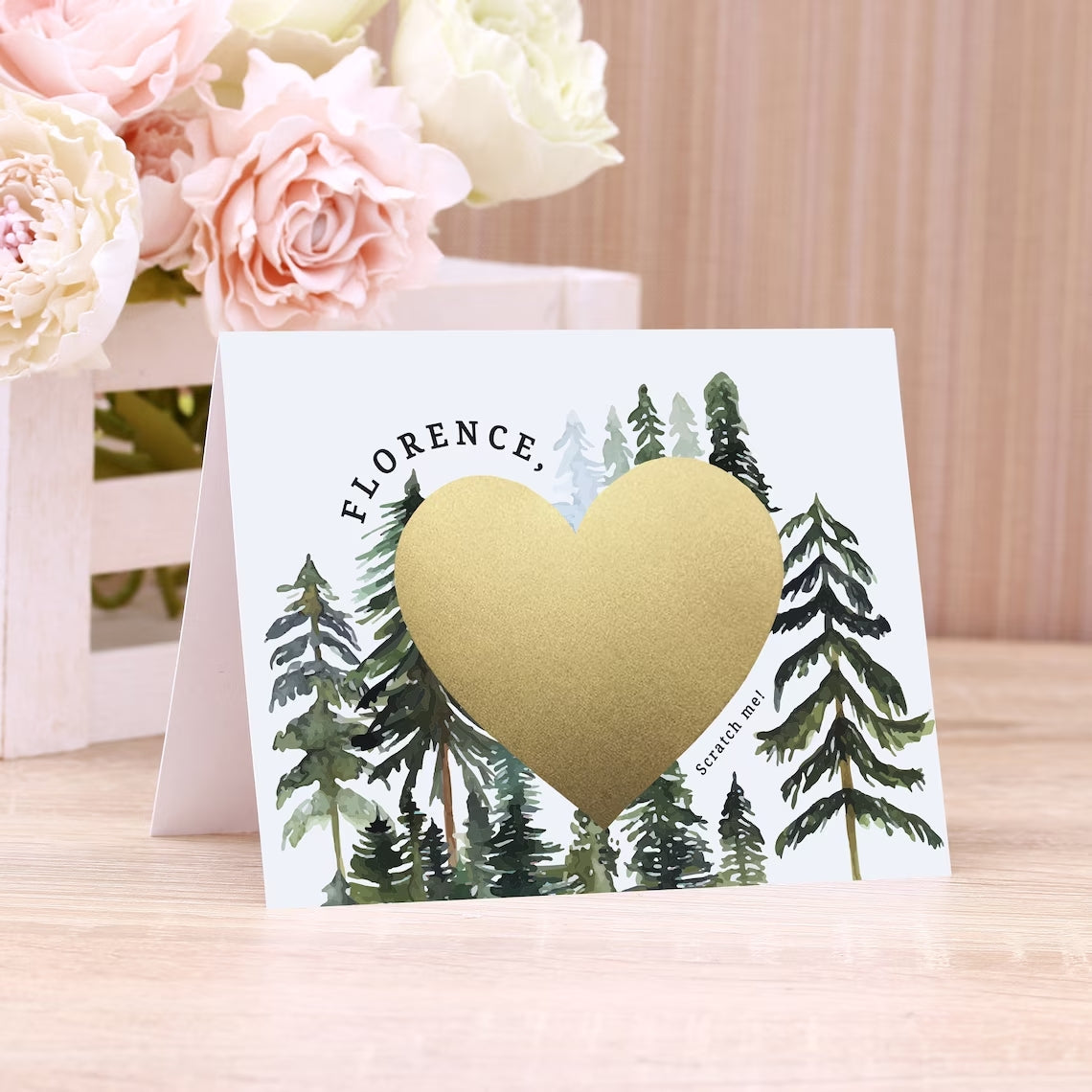 will you be my bridesmaid proposal card with rustic pine trees design and gold foiled cratch off heart in the middle. 