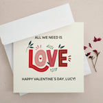 Greeting card with large decorative “LOVE” text and floral accents, styled with minimal background and envelope — XOXOKristen.