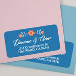 Sheet of personalized floral return address labels with orange blossom and leaves, bold blue background, elegant white script - XOXOKristen
