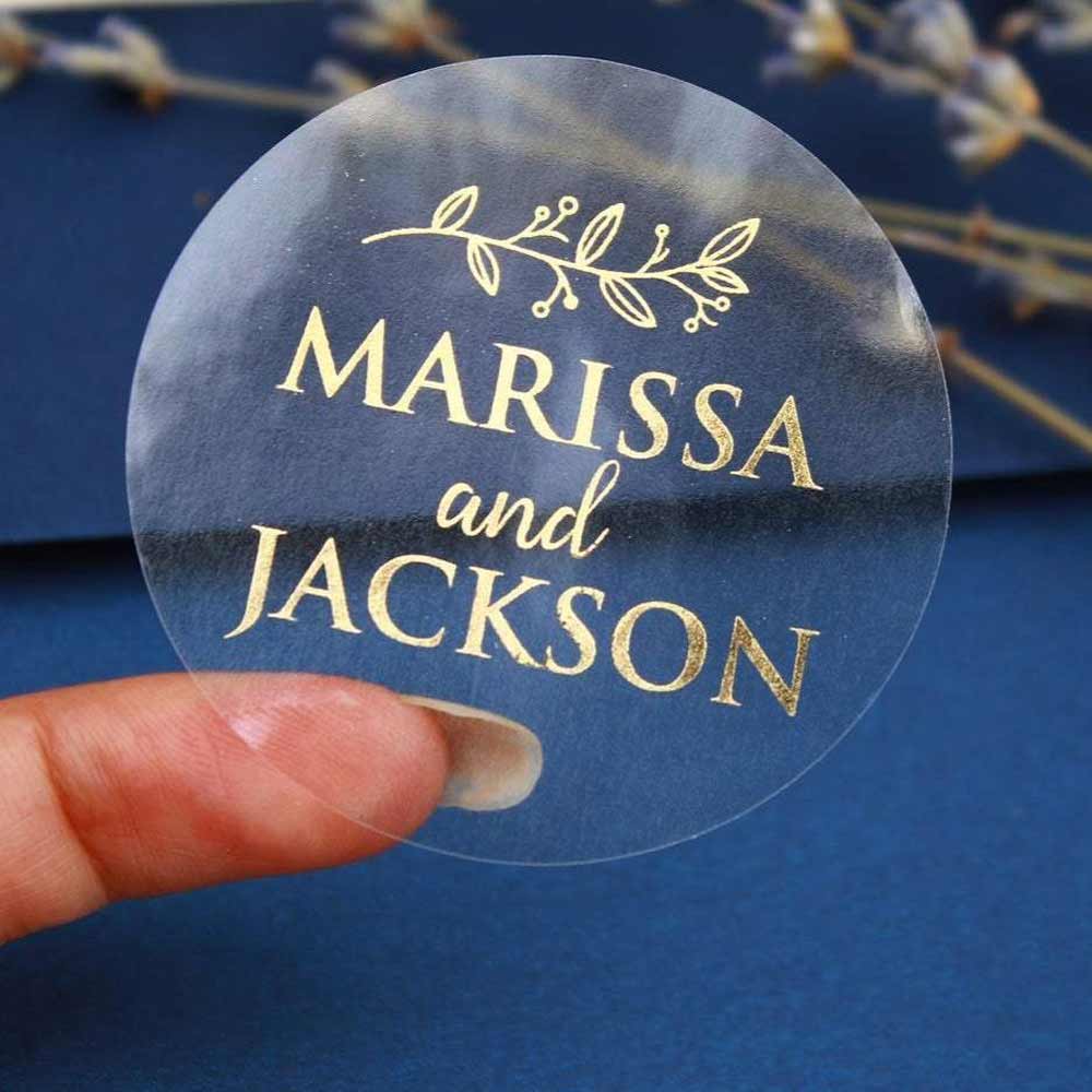 Custom wedding sticker with real gold foiled lettering and leaf ornament. Entirely personalized clear labels.