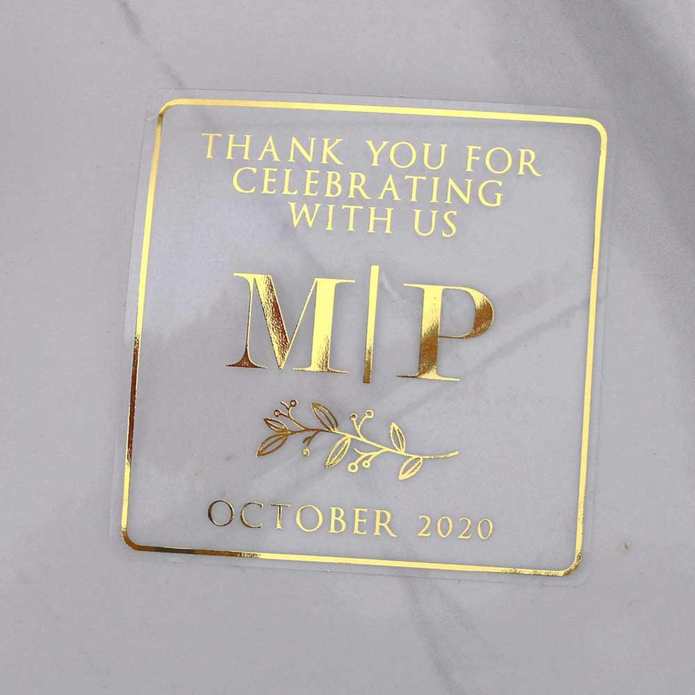 Custom gold foiled wedding stickers with monogram initials and floral design. Entirely personalized clear labels.