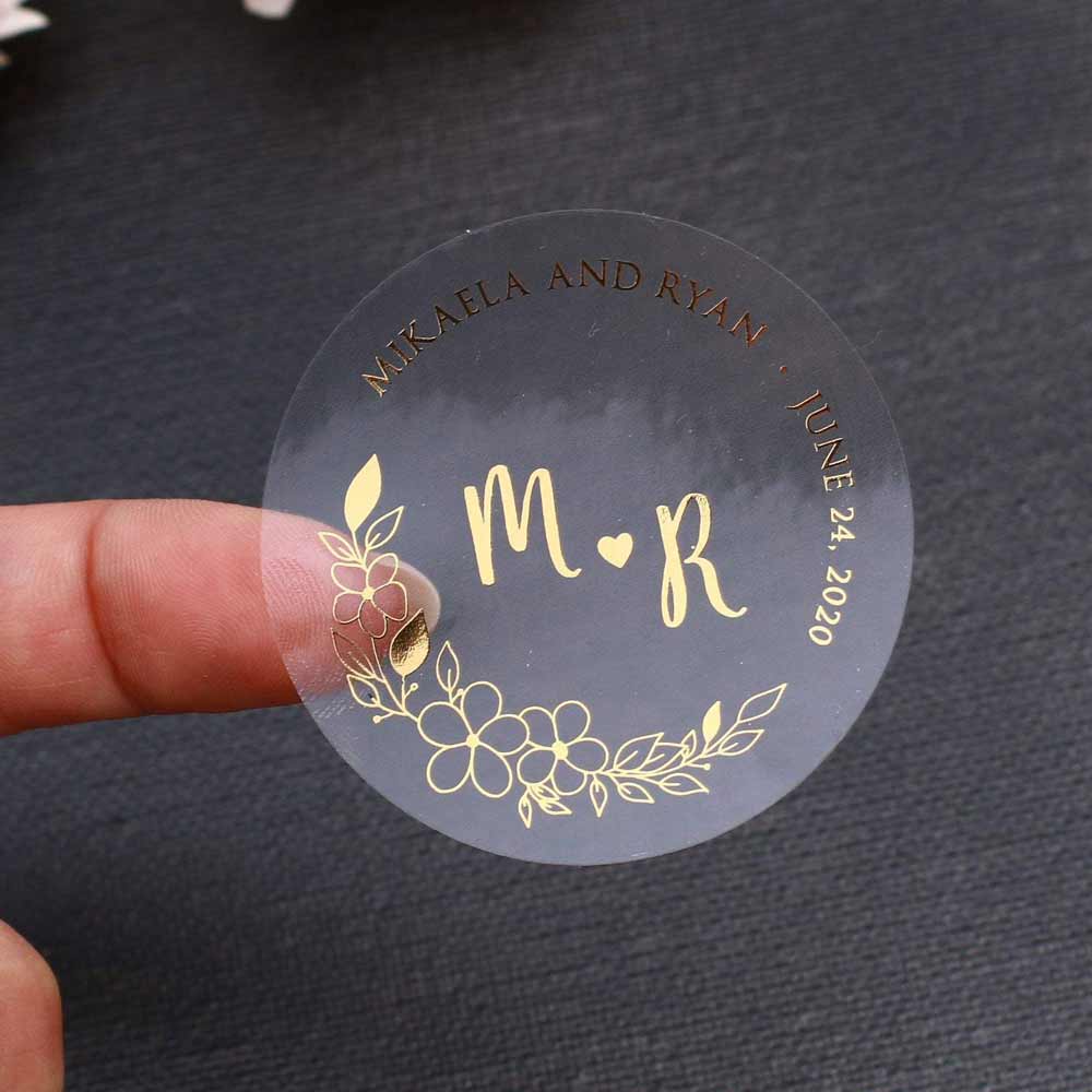 Custom wedding sticker with real gold foiled lettering and flower ornament. Entirely personalized clear labels.
