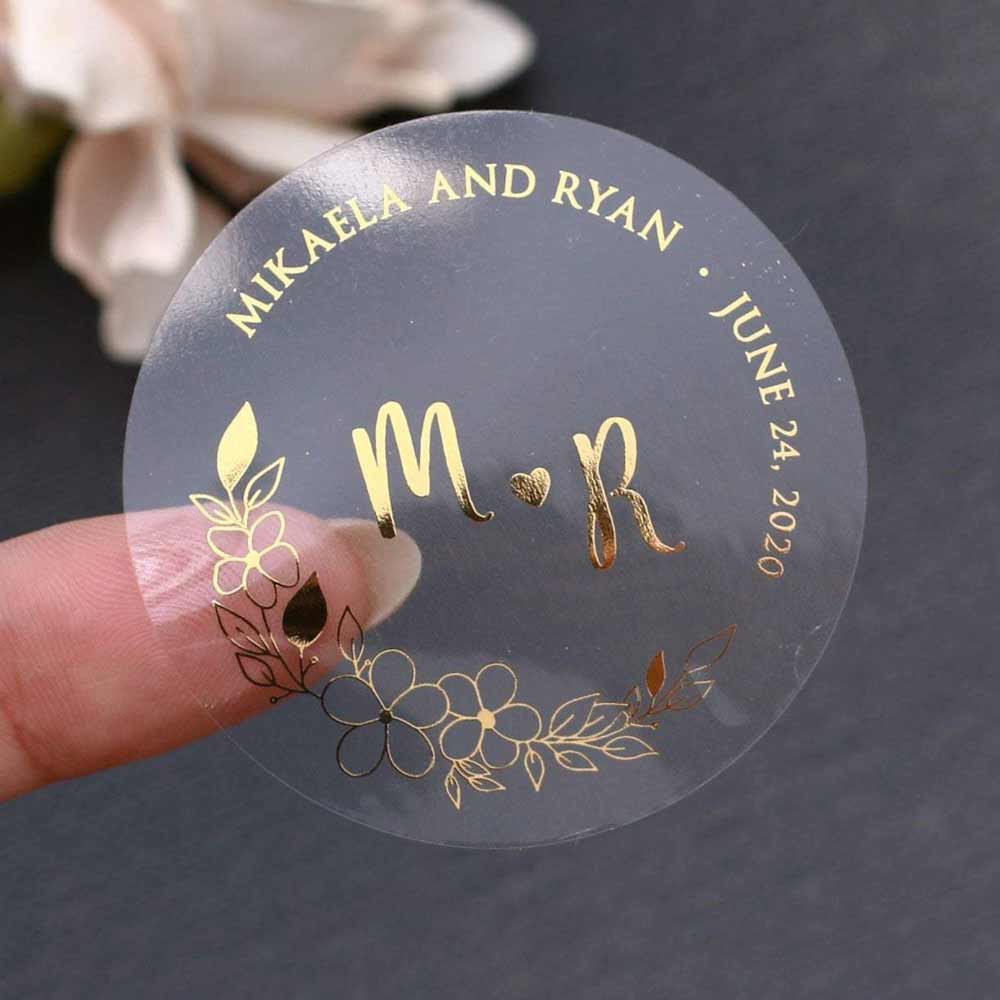 Custom wedding sticker with real gold foiled lettering and flower ornament. Entirely personalized clear labels.